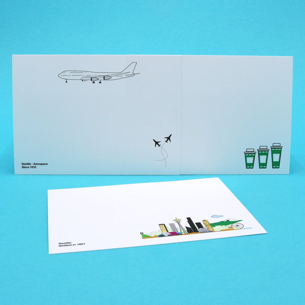 Writing cards with illustrations of Seattle's skyline and landmarks, and iconic Seattle products like Boeing 747s and coffee.