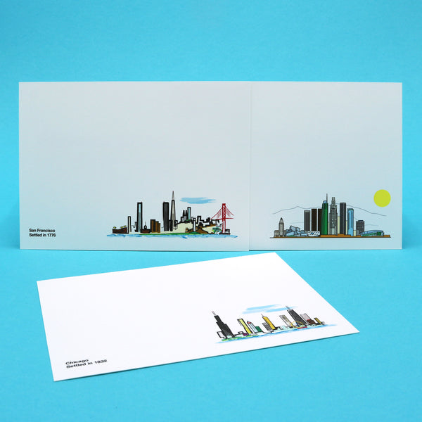 Notecards with illustrations of the Los Angeles, Chicago and San Francisco skylines.
