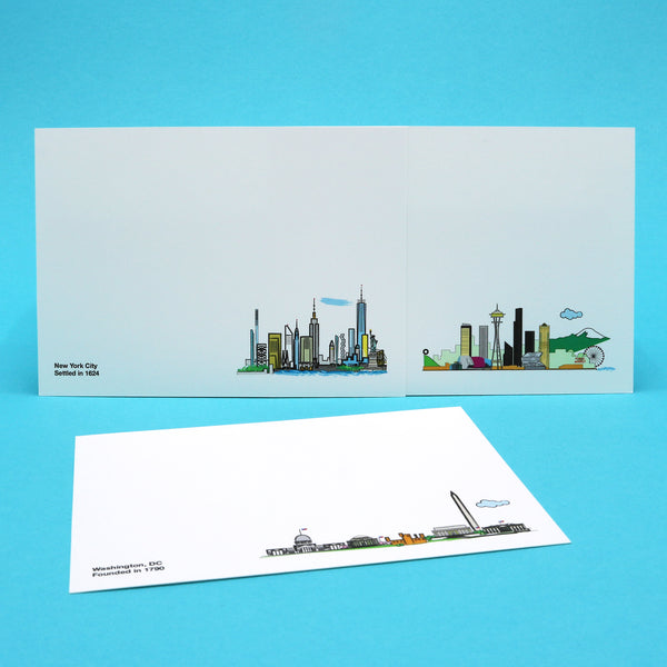 Notecards with illustrations of the New York City, Seattle and Washington, DC skylines.